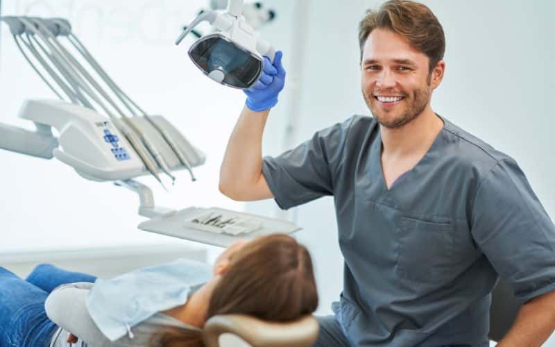 a smiley dentist with a patient in the office